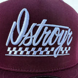 DSTROYR No Destination Long Weekend hat in maroon — close-up detail of embroidered automotive logo